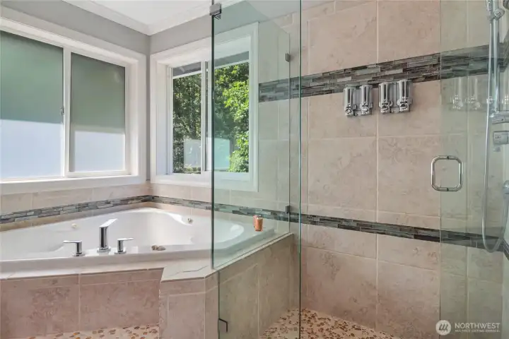 The primary bath features a corner jetted tub and frameless glass shower with 1/2" thick glass. A rain head shower head makes your shower routine feel like you're at a spa.