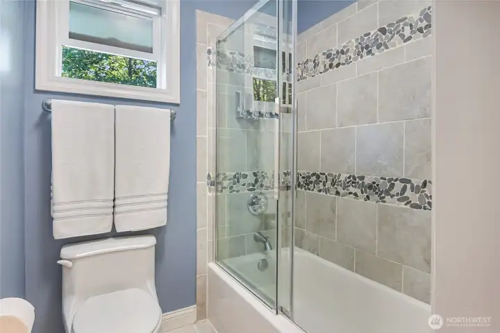 The custom tiled bath/shower in the upper hall bath.