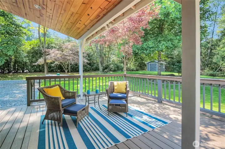 The over-sized, multi-level trex-style deck offers covered and uncovered areas to enjoy year-round. You can see the storage shed in the distance.