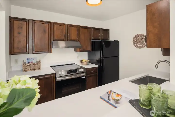 The kitchen features a brand new range and hood as well as new quartz counters and lighting.