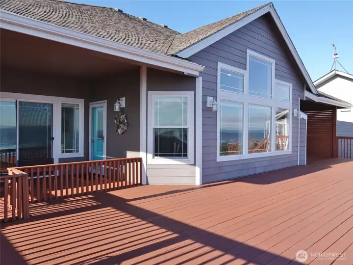 Rear view of this home with large windows, and a huge deck.