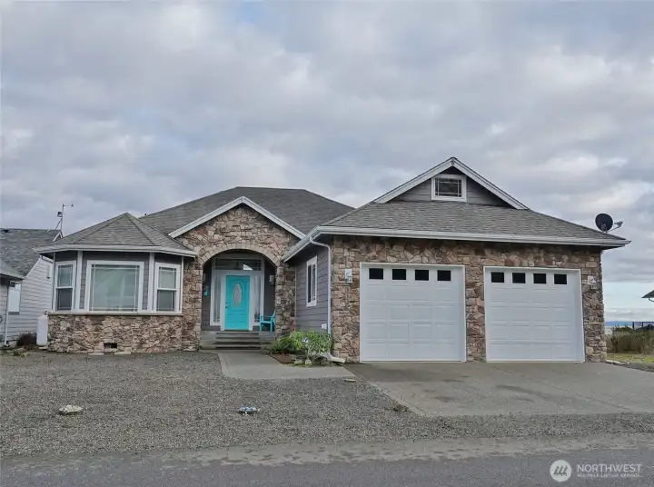 Front of this Craftsman-style home with 2-car Garage and a beautiful rock facade.