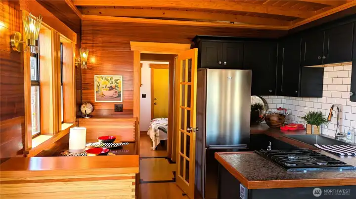 Galley and built-in galley benches, full-sized appliances, mahogany walls and hand-pounded steel countertops