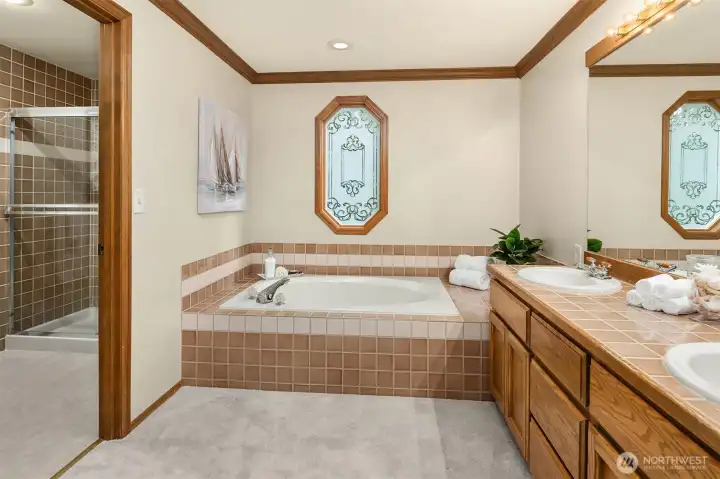 The oversized primary suite also houses a window seat, soaking tub, dual sink and separate tiled shower.