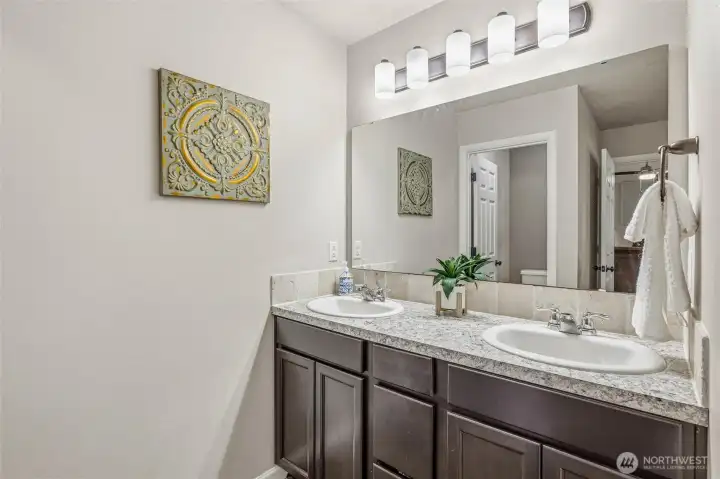 Dual vanities in primary bath with private water closet.