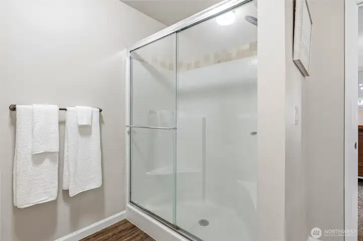 Spacious shower with tile accents in primary bath.