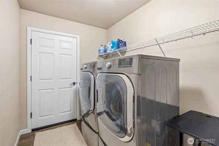 Laundry room with extra storage space and door leading to oversized two car garage.