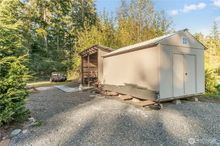 Storage shed and lean too for garden supplies.