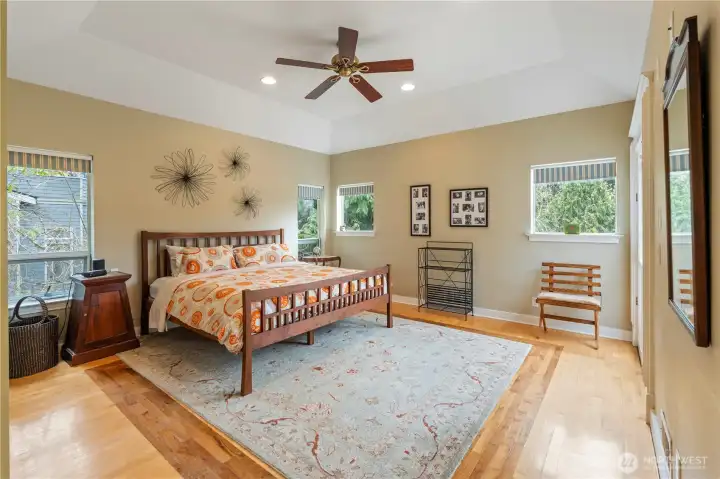 Spacious primary bedroom with door out to large deck. Beautiful hardwood floors with 2 types of wood.