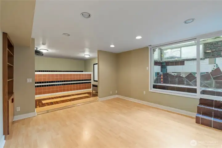 Basement bonus room with projector & screen. Atrium to the right in the photo