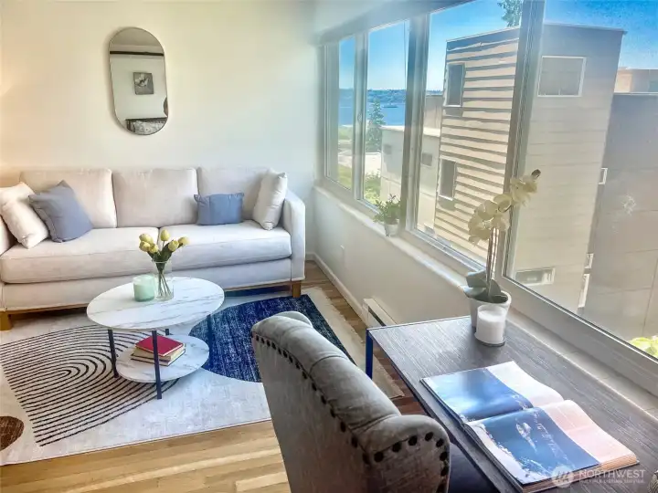 The living room features this West-facing wall of windows with peek-a-boo Elliott bay views for watching ferries, sailboats, tugs, cruise ships and more!