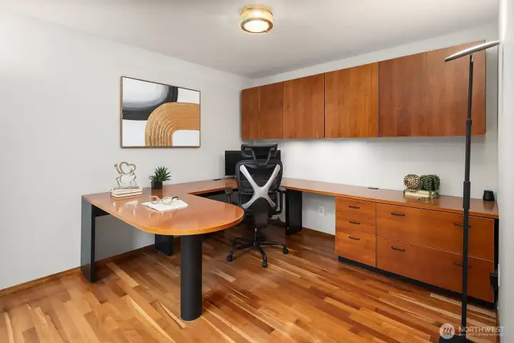 The dedicated main level office features rich built-in cabinetry and warm hardwood floors, creating the perfect work from home setup with style and function in equal measure.
