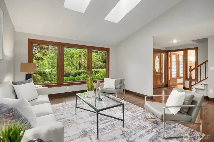 Soaring vaulted ceilings with skylights flood this inviting living space with natural light, while warm hardwood floors and French doors to the outdoors create a seamless connection to the stunning natural surroundings.