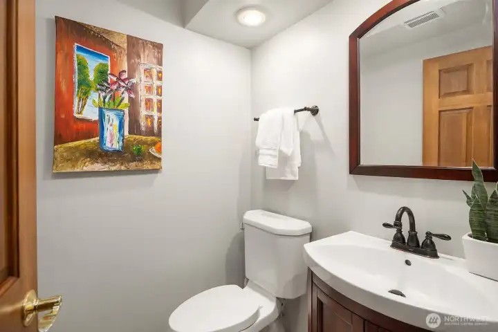 This well-appointed powder room features warm wood accents and thoughtful details that carry the quality and character found throughout the home.