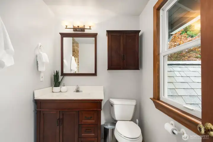 This charming 3/4 bath features rich wood cabinetry and classic finishes, offering comfort and quality for family and guests alike.