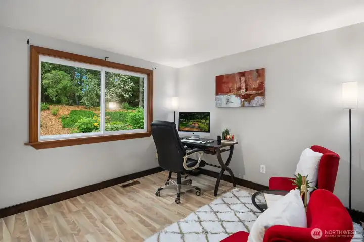 This bright and flexible upper floor room works beautifully as a home office, hobby space, or additional bedroom, with a large window framing peaceful views of the surrounding greenery.
