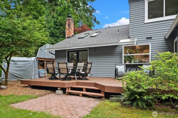 The expansive rear deck and beautifully landscaped yard offer a wonderful extension of the living space, with plenty of room for outdoor dining, relaxing, and enjoying the serene natural surroundings