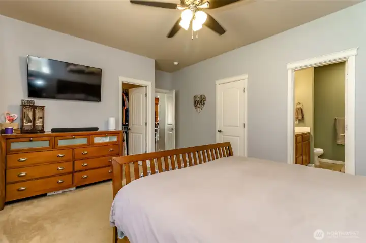 Primary bedroom w/ both closet doors and entry into primary bath