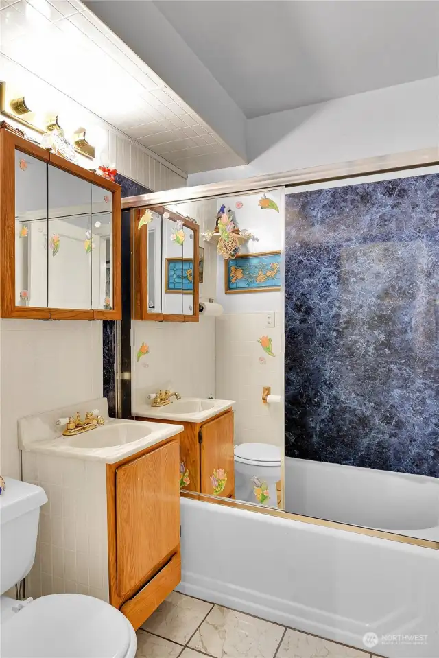 Main floor full bath. Tile floor and mirrored door on tub/shower.