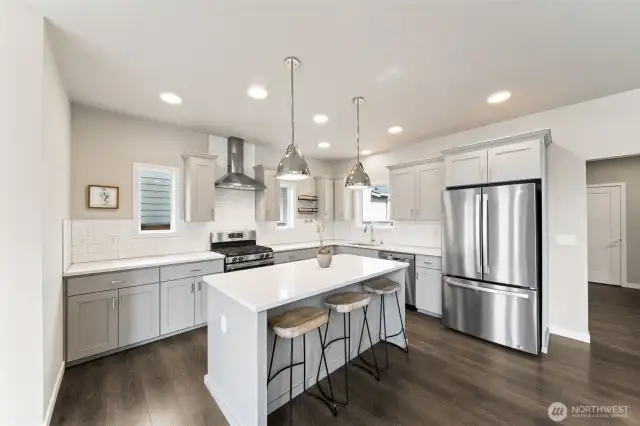 Kitchen with gas range, full tile backsplash.