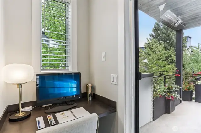 Computer nook next to lovely, covered deck that has a water spigot for watering pots