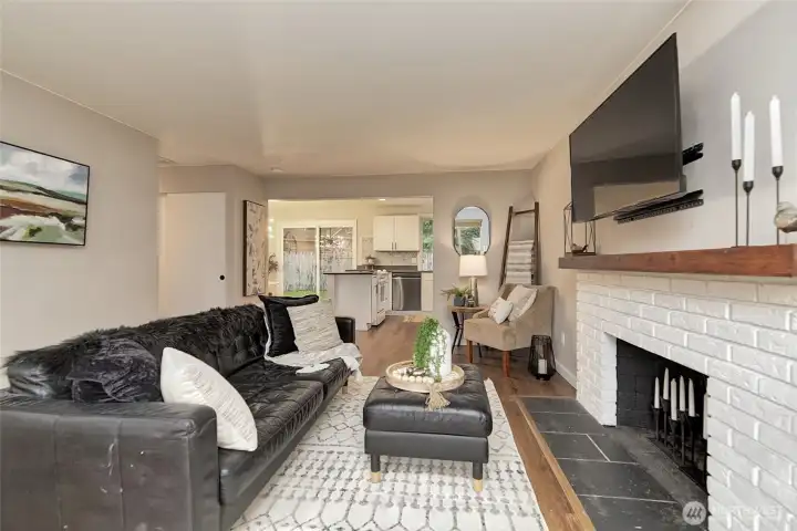 The living room has great sightlines to the kitchen and a cozy wood burning fireplace for those cooler nights!