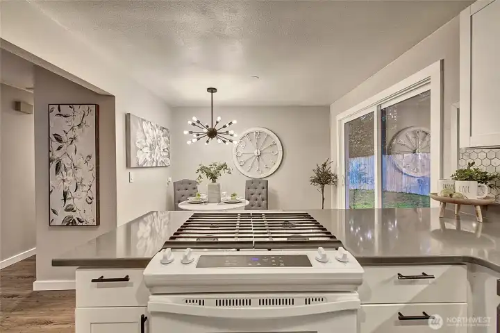 Charming kitchen with quartz countertops and gas stove.
