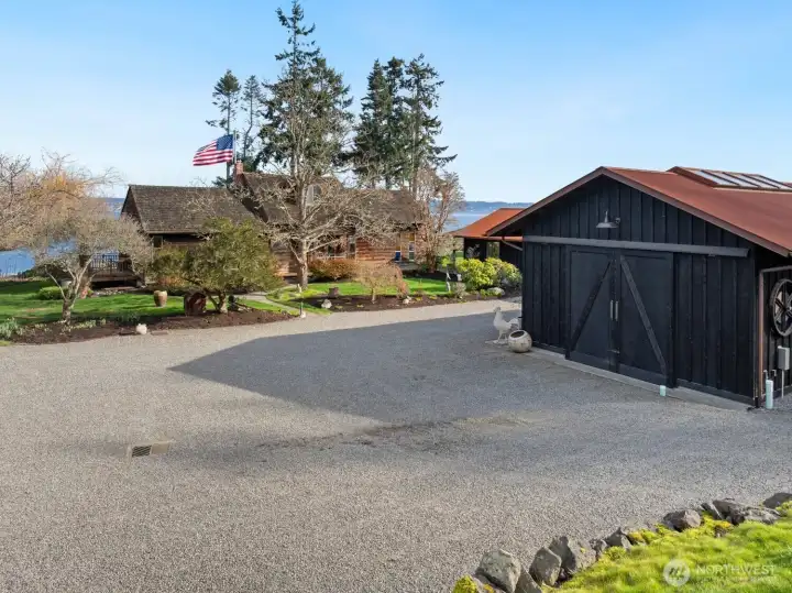 The dedicated 600 square foot workshop is to the right.  There's a lot of extra parking and turn-around area in addition to the 2-car garage.  Notice the water views surrounding the house!