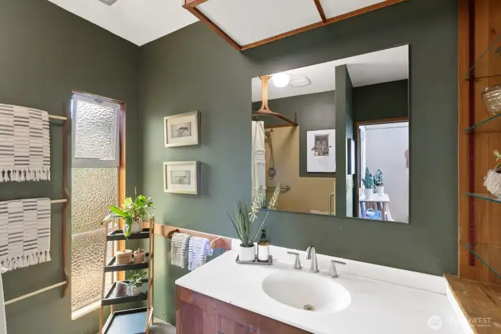 The primary bathroom, with the shower reflected in the mirror.
