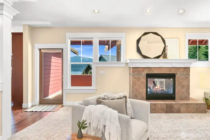 Double sided fireplace in living room with a door on each side provides access to expansive deck