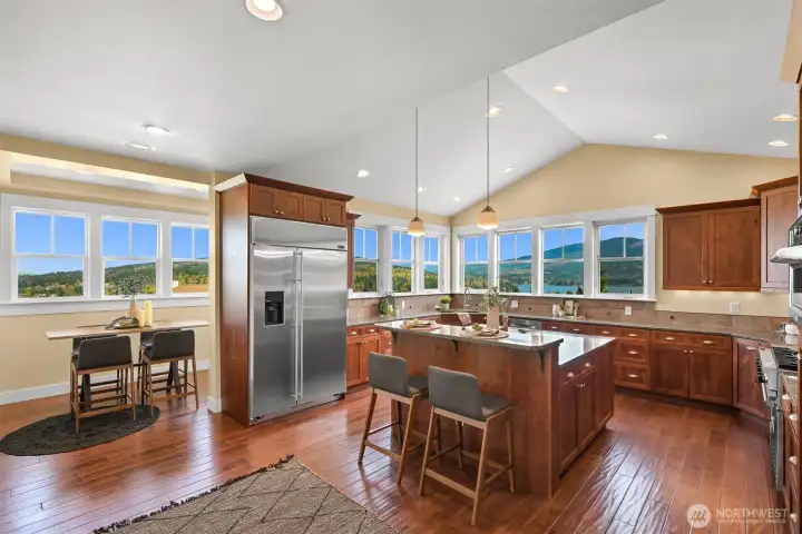 Eating nook to the left and large kitchen with granite and stainless appliances feature expansive lake views to enjoy while cooking and entertaining