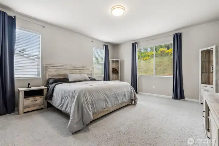 Large primary bedroom with large windows