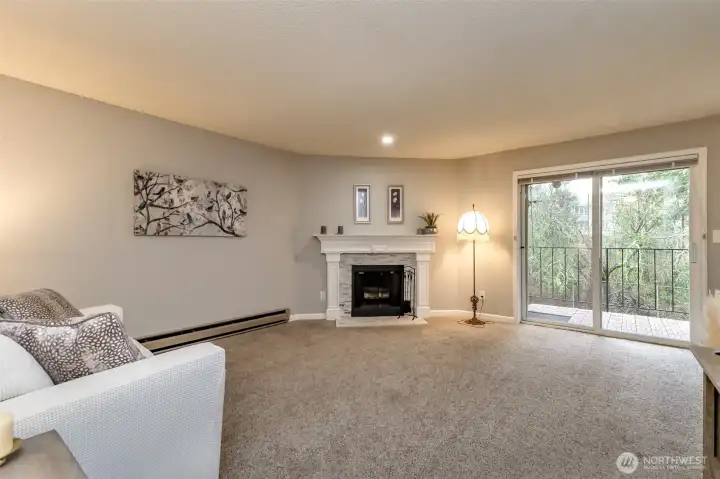 Cozy living room with updated fireplace surround and warm lighting, perfect for relaxing evenings.
