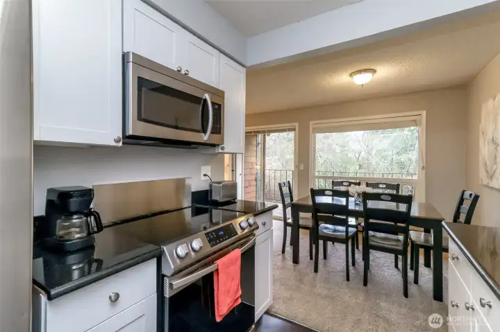 Modern kitchen featuring stainless steel refrigerator, range, and microwave with clean, updated finishes.
