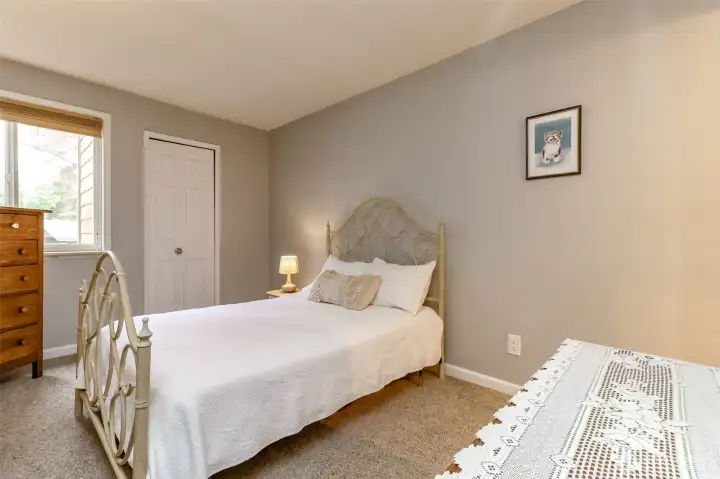 Spacious primary bedroom with plush carpet, large closet, and calming color palette.