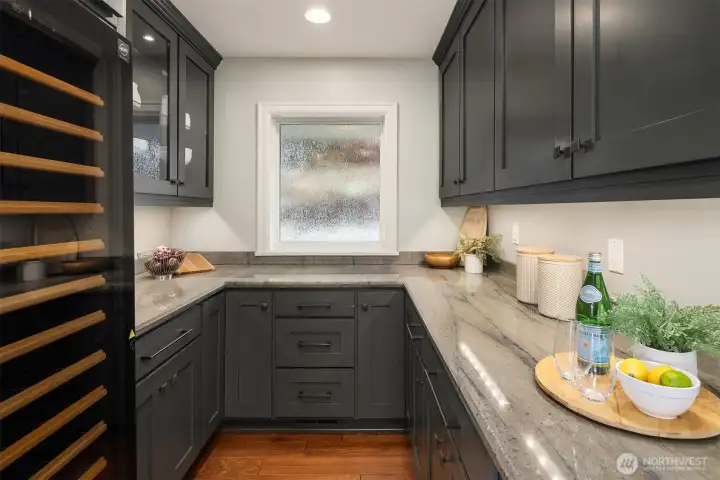 A true extension of the kitchen—custom shaker cabinetry, quartzite countertops, and a EuroCave wine fridge create a refined prep and storage space designed for both function and indulgence.