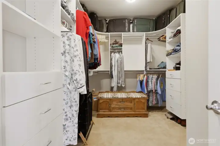 Primary closet with built ins and door into Laundry room