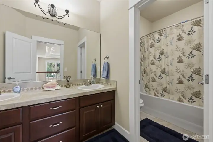 Full Bathroom upstairs has double sink vanity and privacy door for shower.