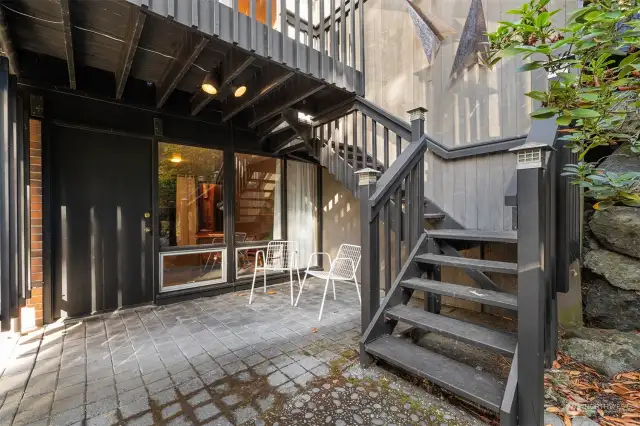 Patio off the lower bedroom/office. Stairs go up to the front door.