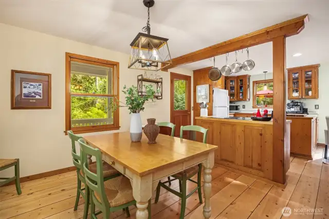 The dining room sits off the kitchen and also showcases the wide plank wood floors.