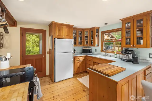 The kitchen includes all wood cabinets and a door to the wrap around deck overlooking the pond.