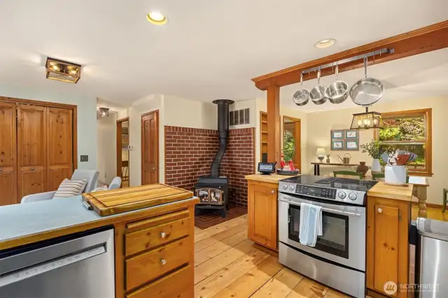 A view from the kitchen to the dining area, sitting area and freestanding wood stove.