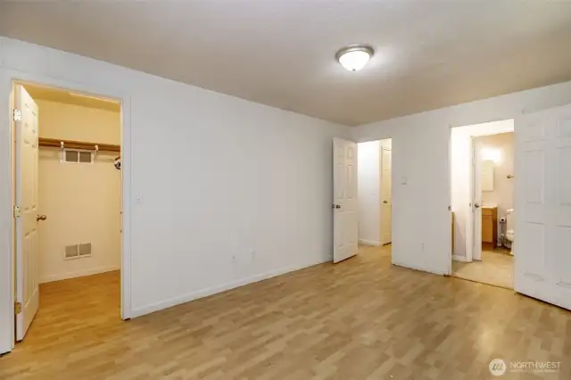 Primary bedroom with half bath and walk-in closet.