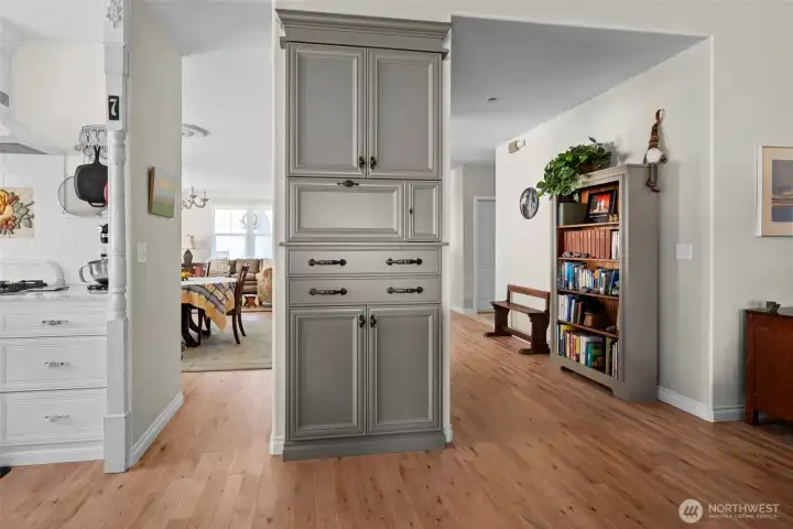 Looking into the Living and dining room from the Kitchen . The kitchen is adorned with custom cabinets.  You are looking at the pantry with a space for the microwave.