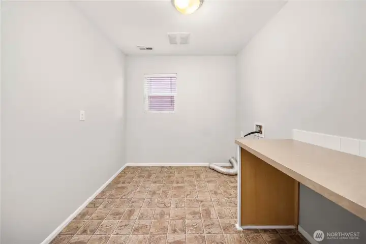Upstairs laundry room with storage and folding table
