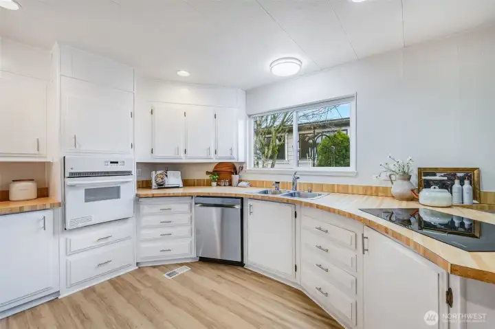 Painted whit cabinets reflects the abundance of natural light in this efficient kitchen.