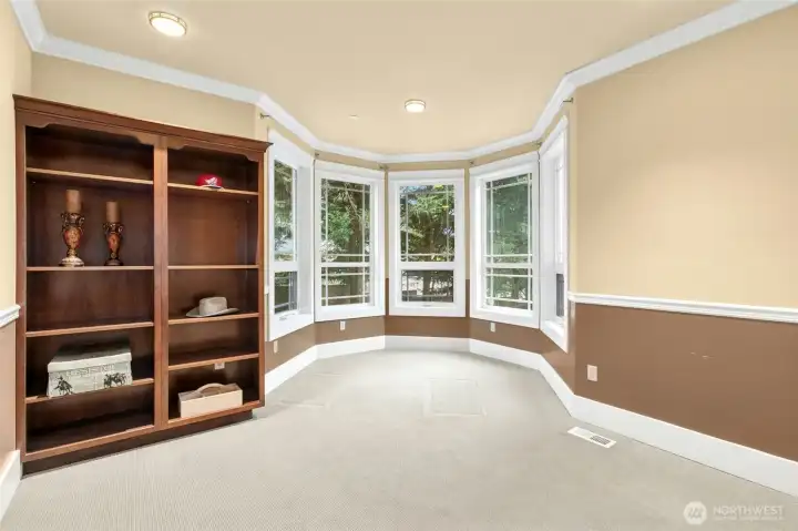 Elegant main-floor den or private office with custom built-ins and expansive windows that fill the space with natural light.