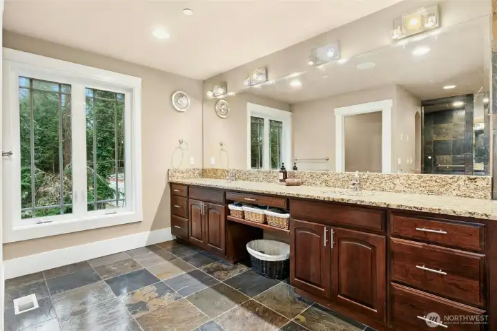 Elegant primary bathroom offering dual vanities and generous custom cabinetry for exceptional storage.