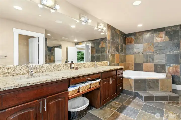 Elegant primary bathroom offering dual vanities and generous custom cabinetry for exceptional storage.