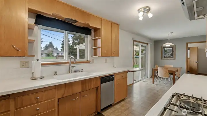 Kitchen with views of backyard and slider leading to covered patio.